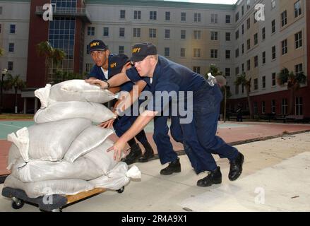 US Navy Studenten, die dem Naval Air Technical Training Center (NATTC) an Bord der Naval Air Station Pensacola, Florida, zugeteilt sind, arbeiten zusammen, um ihre Baracken von Trümmern zu befreien Stockfoto