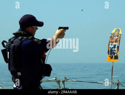 US Navy Ein 9mm-Pistolengehäuse fliegt in der Luft, während ein Matrose, der der Royal Australian Navy zugeteilt wurde, an einer Handfeuerübung auf der Vorderseite der Royal Australian Navy Fregatte HMAS Adelaid teilnimmt Stockfoto