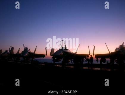 DIE US Navy F-A-18 Hornets sind entlang des Bugs an Bord des Flugzeugträgers USS Harry S. Truman der Nimitz-Klasse (CVN 75), bevor der Nachtflugbetrieb im Persischen Golf beginnt Stockfoto