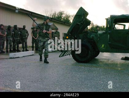 US Navy Steel Worker 1. Klasse zugewiesen zum Naval Mobile Construction Battalion Seven (NMCB-7), zeigt seinen Seabees, wie man ein Fahrzeug während Block tr Stockfoto