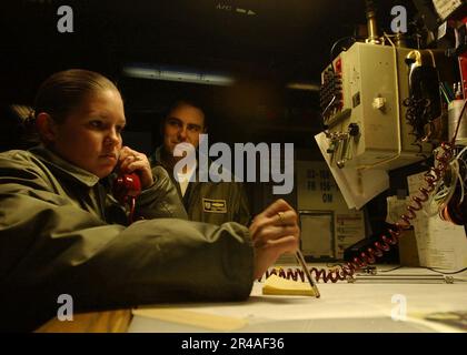 US Navy Aviation Warfare Systems Operator 1. Klasse links, kommuniziert mit den USA Die Küstenwache streitet sich unter der Aufsicht von LT. Commander. In der Anti-U-Boot-Kriegsführung Mo Stockfoto