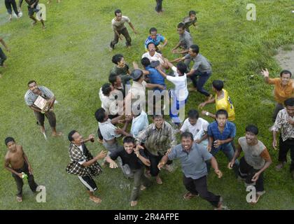 Indonesische Flüchtlinge DER US Navy versammeln sich unter einem herannahenden Helikopter, um Nahrung und Vorräte zu erhalten Stockfoto