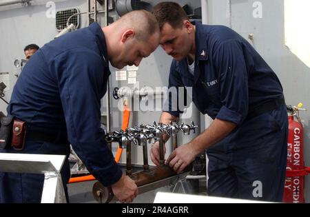 WARTUNGSTECHNIKER DER US Navy Hull 1. Klasse links und Techniker der Rumpfwartung 3. Klasse Bereiten Sie sich auf die Prüfung eines Verteilers für Frischwasser vor Stockfoto