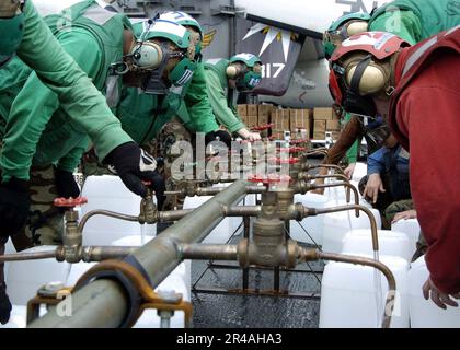 MITGLIEDER der US Navy Crew an Bord der USS Abraham Lincoln (CVN 72) füllen die Kannen mit gereinigtem Wasser aus einem Trinkwasserverteiler Stockfoto