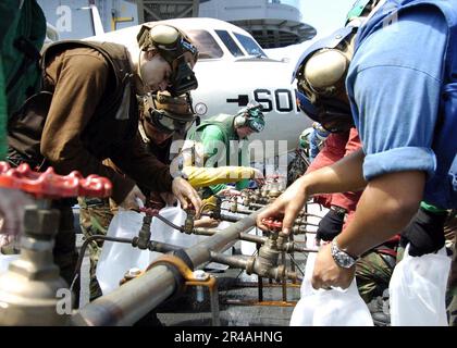 MITGLIEDER der US Navy Crew an Bord der USS Abraham Lincoln (CVN 72) füllen die Kannen mit gereinigtem Wasser aus einem Trinkwasserverteiler Stockfoto