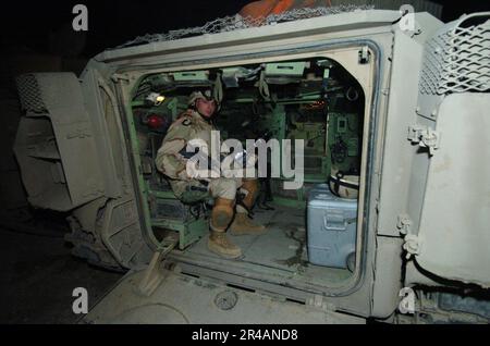 DIE MATE 1.-Klasse DES US Navy Photographers ist der Fleet Combat Camera Atlantic zugewiesen und bereitet sich auf eine Fahrt in einem M2A3 Bradley Kampffahrzeug vor, während er die USA fotografiert Soldaten Der Armee Stockfoto