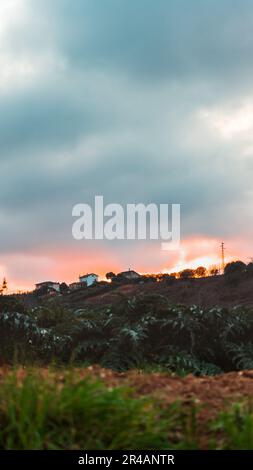 Eine vertikale Aufnahme von Häusern auf dem Land bei Sonnenuntergang Stockfoto