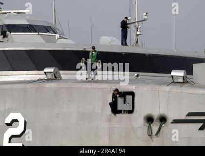 US Navy Line Handler an Bord des Hochgeschwindigkeitsschiffs Two (HSV 2) Swift, bereiten sich darauf vor, Anlegestellen zu werfen, während Swift sich auf das Anlegen in Augusta Bay, Sizilien, vorbereitet. Stockfoto