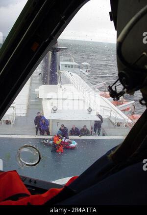 US NAVY A U.S. Coast Guard Air Station Sitka, Alaska HH-60J Jayhawk Hubschraubercrew umkreist die Alaska Marine Highways Systems Fährschiff Kennicott, bevor ein 69-jähriger Patient 65 Meilen nordwestlich von der Luft gehoben wurde. Stockfoto