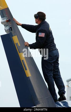 US Navy Ein Seemann, der den USA zugeteilt wurde Das Navy Flug Demonstrationsteam, die Blue Angels, führt nach dem Flug eine Inspektion des vertikalen Stabilisators des gegenüberliegenden Solo F-A-18A Hornet Aircraft du durch. Stockfoto