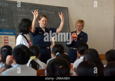 US Navy Zahntechniker 2. Klassenzentrum, und Senior Chief Hospital Corpsman rechts, demonstrieren richtige Zahnhygiene für eine Gruppe von 5. und 6. Schüler an einer Schule in N.. Stockfoto