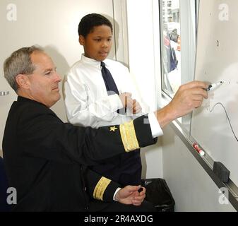 US Navy Commander, Navy Recruiting Command, Konteradmiral Jeffrey Fowler, bespricht Wettermuster mit Schülern der Math, Civics and Science Charter School. Stockfoto