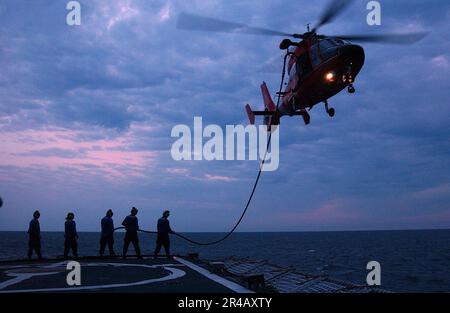 MITGLIEDER der US Navy Crew sind an Bord der USA stationiert Coast Guard Cutter Valiant (WMEC 621), passieren Sie eine Treibstoffleitung zu einer HH-65 Dolphin Hubschraubercrew während einer Übung im Golf von Mexiko. Stockfoto