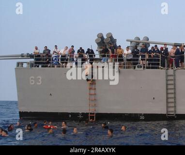 Mitglieder der US Navy Crew, die dem geführten Raketenkreuzer USS Cowpens (CG 63) zugeteilt sind, genießen einen Badegang im Pazifik. Stockfoto