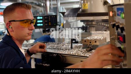 US Navy Machinery Servicebetrieb der Klasse 3. verwendet eine universelle Fräsmaschine, um ein Aluminiumstück in der Maschinenwerkstatt an Bord des Flugzeugträgers USS Ronald Reagan (CVN 76) der Nimitz-Klasse zu fräsen. Stockfoto