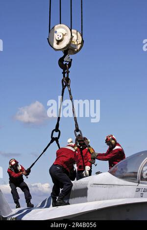 MITARBEITER des US Navy Flight Decks, die dem Air Department zugewiesen sind, führen Flugzeugbergungsübungen durch. Stockfoto