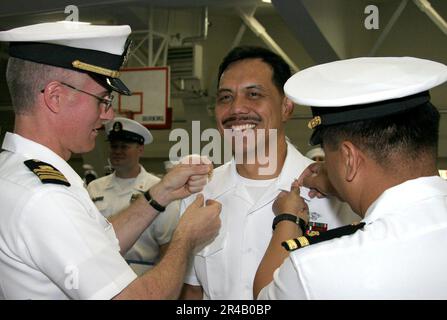 DER leitende Petty Officer der US Navy lächelt, während seine leitenden Anker während einer krassen Zeremonie an Bord der Naval Air Facility Atsugi festgehalten werden. Stockfoto