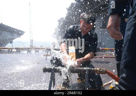 US Navy Yeoman Klasse 2. passt einen Keil in ein gerissenes Rohr. Stockfoto