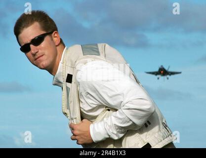 US Navy LT. Wartet darauf, dem Landing Signal Officer (LSO) während eines Bergungszyklus an Bord des konventionell angetriebenen Flugzeugträgers USS Kitty Hawk (CV 63) ein freies Deck zu signalisieren. Stockfoto