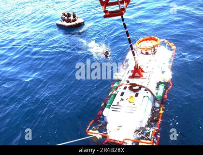 US Navy Petty Officer 3. Klasse schwimmt zum britischen U-Boot Rettungsfahrzeug LR-5, um den Kran zu lösen, als er vom finnischen Schiff Fennica abgesenkt wurde. Stockfoto