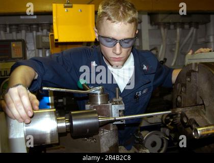 US Navy Machinery Servicebetrieb der Klasse 3. verwendet eine Drehmaschine, um ein Stück Kohlenstoffstahl zum Gewindedrehen auf 3-8 Zoll zu drehen. Stockfoto