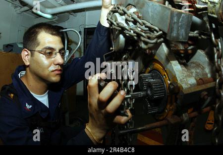 TECHNIKER der Klasse 3. der US Navy Aviation Support Equipment montiert das Motorgetriebe auf einem pneumatischen Hebezeug. Stockfoto