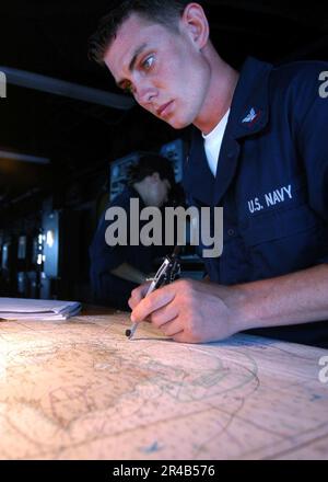 QUARTERMASTER der US Navy 2. Class stellt den Kurs des Schiffes an Bord des Landungsschiffes USS Pearl Harbor (LSD 52) fest. Stockfoto