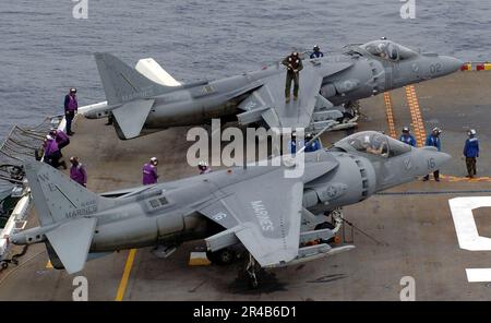 US Navy Sailers arbeiten zusammen, um ein Marine Corps AV-8B Harrier II zu befeuern, das dem Angriffsgeschwader zwei Eins vier (VMA-214) zugeteilt wurde. Stockfoto