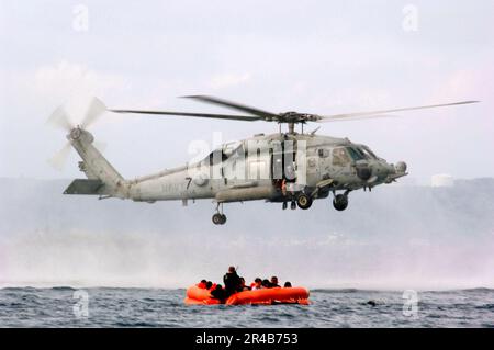 US Navy USA Mitarbeiter der Luftwaffe, die der 18. Aeromedizinischen Evakuierungsschwadron (AES), Luftwaffenstützpunkt Kadena, Japan, zugeteilt sind, bereiten sich auf eine simulierte Rettung durch eine US-Regierung vor Navy HH-60H Seahawk Hubschrauber. Stockfoto