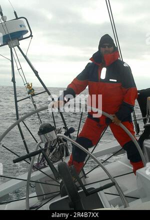 US Navy Hull Technician 1. Class mans am Steuer, während er auf dem Segelboot in Coruba Wache hält Stockfoto
