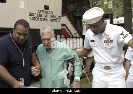 US Navy Yeoman Klasse 2. und ein ziviler Freiwilliger Führer ein pensionierter Militärveteran, der von Gulfport zu einem Walker transportiert wurde. Stockfoto