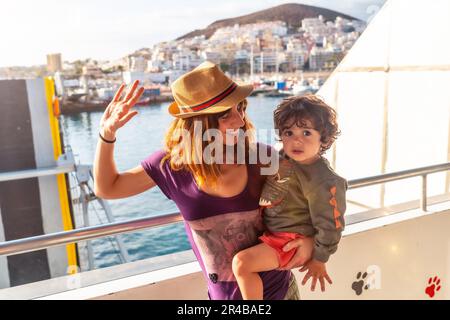 Mutter und Sohn im Urlaub auf der Fähre und die Stadt Los Cristianos im Hintergrund auf der Insel Teneriffa. Fähre von La Gomera Stockfoto