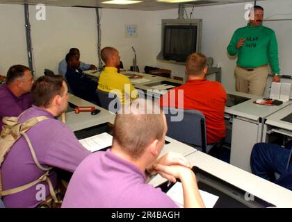 DER Mate von SENIOR Chief Aviation Boatswain der US Navy weist sein Team von Aviation Boatswain's Kumpels an, was sie erwarten können, wenn sie an der Golfküste ankommen, um hur bereitzustellen. Stockfoto