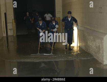 US Navy USA Navy-Matrosen, die dem Amphibienschiff USS Bataan (LHD 5) zugeteilt sind, helfen dabei, Wasser zu entfernen und einige der Schäden zu beseitigen, die durch den Hurrikan Katrina im Gebiet von Biloxi verursacht wurden. Stockfoto