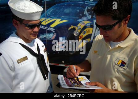 US Navy Aviation Boatswains Mate 2. Class erhält ein Autogramm vom Navy Dodge Charger NASCAR-Fahrer David Stremme. Stockfoto