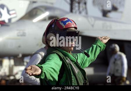 LAGERHÜTER der US Navy Klasse 3. signalisiert an einen MH-60s Seahawk Helikopter während einer vertikalen Auffüllung an Bord des nuklearbetriebenen Flugzeugträgers USS Nimitz (CVN 68). Stockfoto