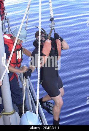 US Navy USA Navy Petty Officer 3. Klasse A Such- und Rettungsschwimmer, wird über die Seite von einem Seemann unterstützt Stockfoto