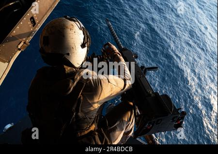 EIN US-AMERIKANISCHER Marinekorps MV-22 Osprey Crew Chief zugeteilt zum Marine Medium Tiltrotor Squadron 266 (VMM-266) lädt .50 Kaliber Kugeln in eine GAU-21, während er am 2. Januar 2023 über den Golf von Aden fliegt, während routinemäßiger Ausbildungsmaßnahmen innerhalb der kombinierten Joint Task Force - Horn of Africa (CJTF-HOA) Area of Responsibility (AOR). VMM-266 wurde zur Unterstützung der CJTF-HOA in Camp Lemonnier (Dschibuti) eingesetzt, indem sie Kapazitäten für den Transport von Kampftruppen, -Vorräten und -Ausrüstung innerhalb Ostafrikas zur Unterstützung des Angriffs bereitstellte. Stockfoto