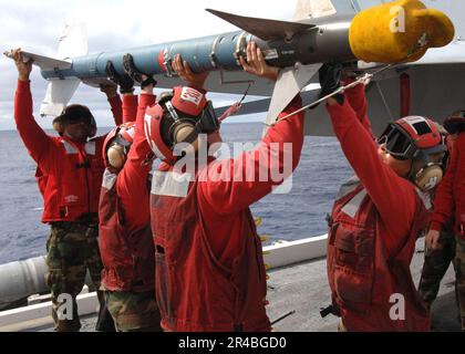 US Navy Aviation Ordnancemen, zugewiesen zum Stier des Strike Fighter Squadron Three Seven (VFA-37), laden ein CATM-9 herunter. Stockfoto