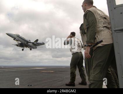 US Navy Landing Signal Officers (LSO) beobachten und bewerten die festgenommene Landung einer F-A-18C Hornet. Stockfoto