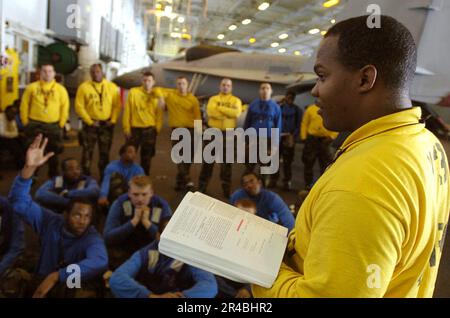 DER stellvertretende leitende Petty Officer der US Navy V-3 Division, Aviation Boatswain's Mate Handling 1. Class, stellt sein Personal in Fragen zur Handhabung und Steuerung von Flugzeugen Stockfoto