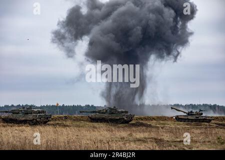 Deutsche Soldaten, die dem 93. Panzerlehr-Demonstrationsbataillon, der 9. Panzerlehr-Brigade, der 1. Panzerdivision und polnische Soldaten, die der 15. Mechanisierten Infanteriebrigade zugeteilt sind, greifen während Amber Lynx, einer kombinierten Feuerübung in Bemowo Piskie, Polen, am 6. April 2023 Ziele an. Die Mission der 4. Infanterieabteilung in Europa besteht darin, sich an multinationalen Schulungen und Übungen auf dem ganzen Kontinent zu beteiligen und mit NATO-Verbündeten und regionalen Sicherheitspartnern zusammenzuarbeiten, um V Corps, Amerikas zukunftsgerichtetes Korps in Europa, mit Kampfkräften zu versorgen. Stockfoto