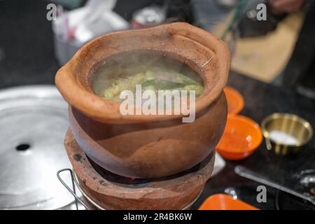 Jim Joom, thailändischer Hot Pot aus dem Nordosten Thailands, enthält Schweinefleisch, Gemüse und Glasnudeln in einer Tonschüssel Stockfoto