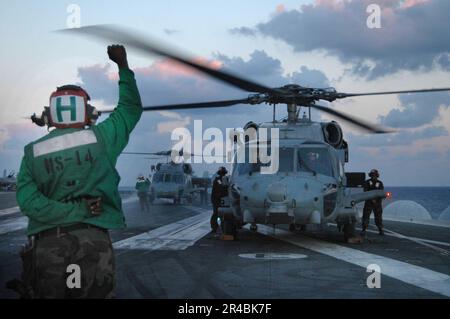 US Navy Ein Matrose, der Helikopter-Anti-U-Boot-Geschwader 14 (HS-14) zugeteilt wurde, signalisiert vor dem Start einen HH-60H Seahawk-Hubschrauber. Stockfoto