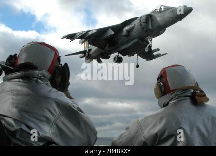 US Navy zwei Mitglieder des Air Department beobachten eine AV-8B Harrier, während sie sich auf die Landung an Bord der USS Iwo Jima (LHD 7) vorbereitet. Stockfoto