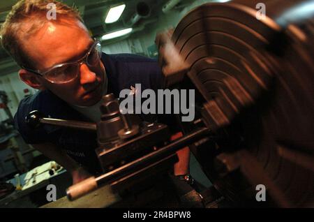 US Navy Machinery Servicebetrieb 3. Klasse der stellvertretende leitende Petty Officer der Maschinenwerkstatt bohrt Löcher für Nachtsichtgerät. Stockfoto