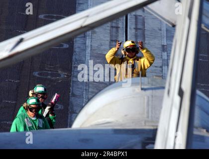 US Navy ein Flugzeugdirektor signalisiert dem Piloten eines S-3B Wikingers, die Flügel zu entfalten. Stockfoto