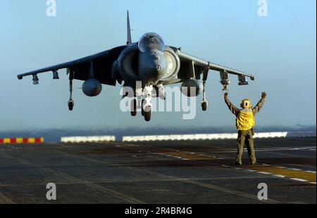 US Navy Aviation Boatswain's Mate 1. Class leitet eine AV-8B Harrier, die auf dem Flugdeck des Amphibienschiffs USS Peleliu (LHA 5) landet. Stockfoto