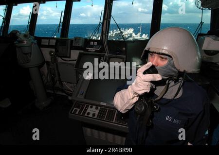 DER US Navy Quartermaster der Klasse 3. betreibt während einer Generalquartierübung auf der Brücke ein schallbetriebenes Telefon. Stockfoto