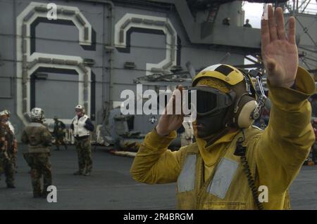 US Navy mit einem bemalten Gesicht signalisiert ein Flugzeugdirektor eine F-A-18E Super Hornet. Stockfoto